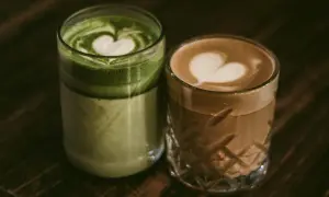 Zielone matcha latte i kawowe latte z serduszkami na piance. Dylemat: kawa czy herbata?