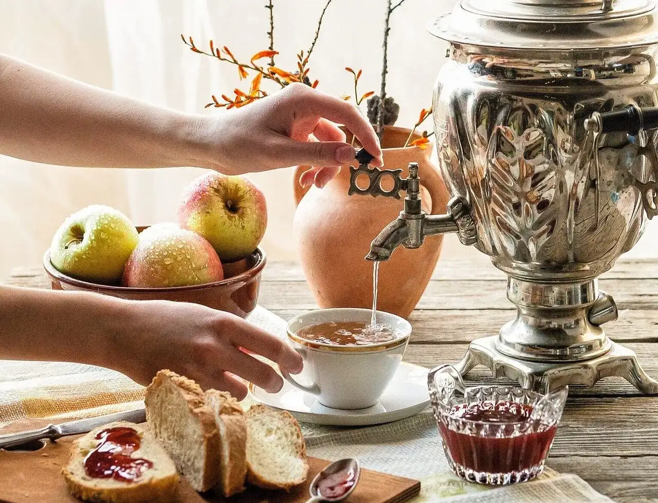 Tradycyjna herbata po rosyjsku z samowara, podana z dżemem, jabłkami i świeżym chlebem.